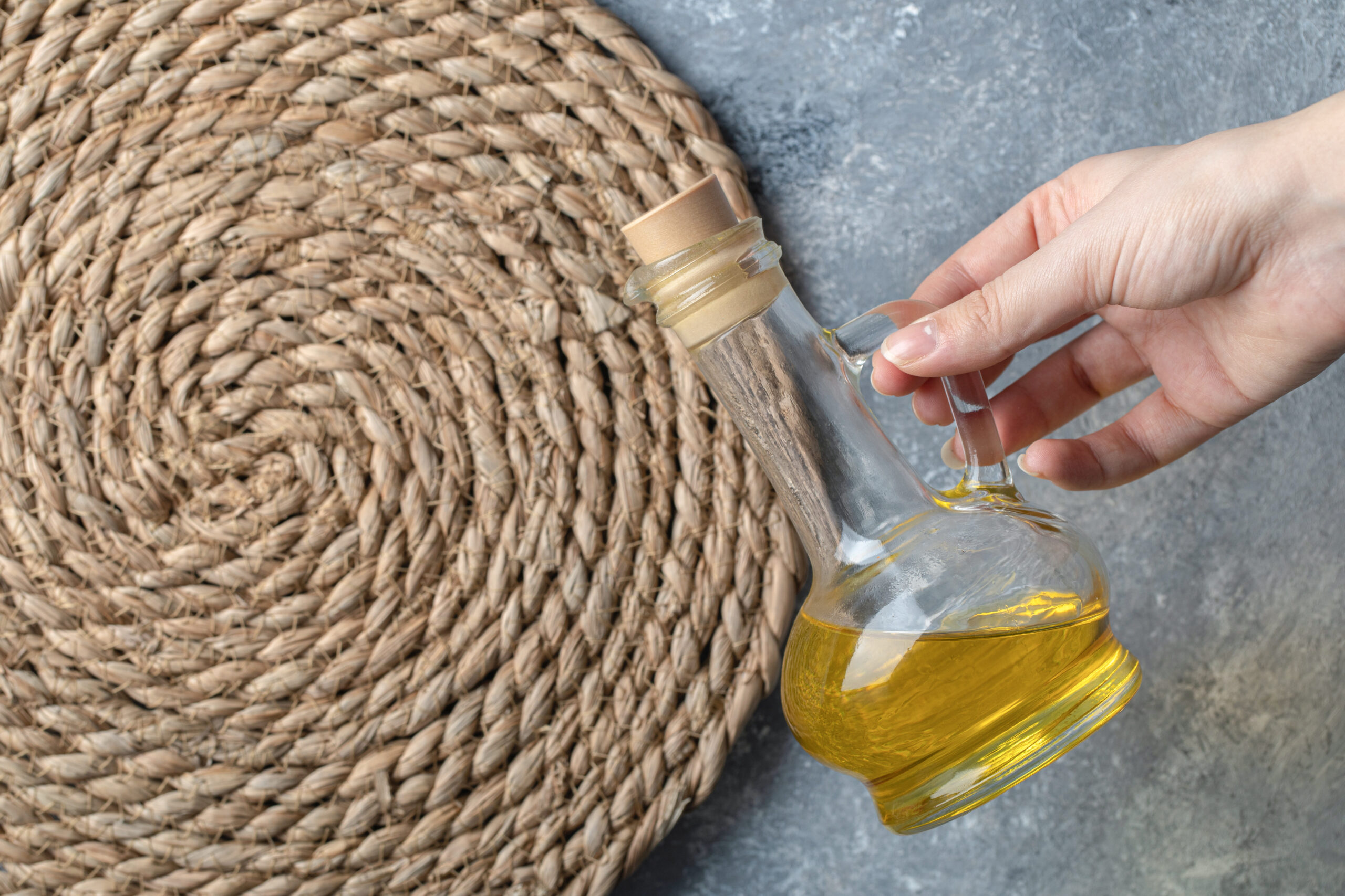 Female hand holding bottle of oil. High quality photo